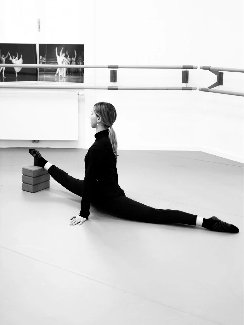 A dancer in the splits, the front leg resting on blocks